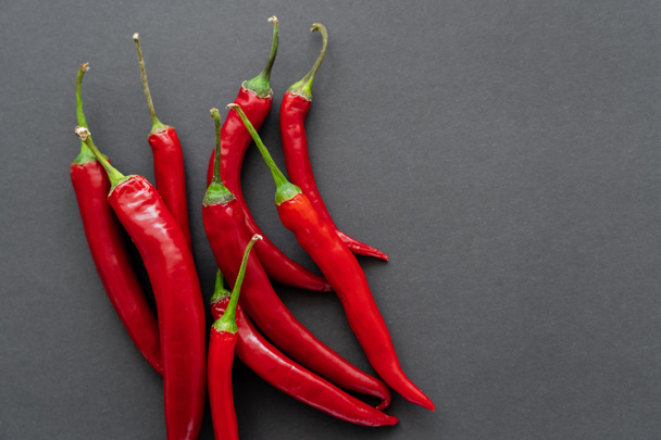 Top view of ripe chili peppers on black background  - 写真・画像