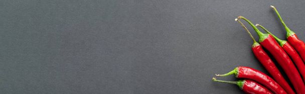 Widok z góry ostre papryki chili na czarnym tle, baner  - Zdjęcie, obraz