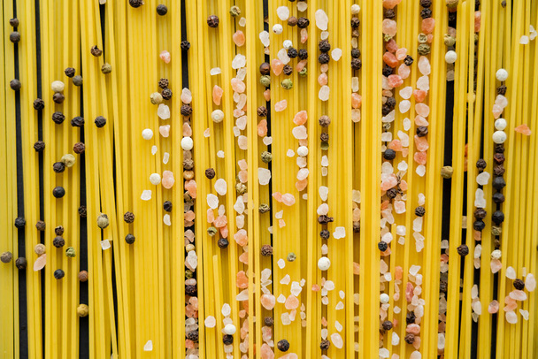 Вид зверху спеції на сирому спагеті на чорному тлі
  - Фото, зображення