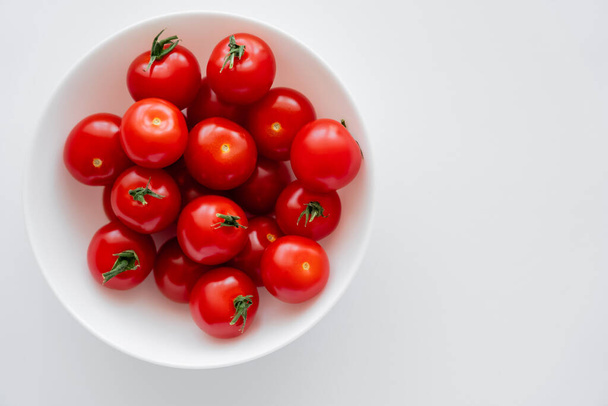 Top view of fresh cherry tomatoes in bowl on white background  - Valokuva, kuva