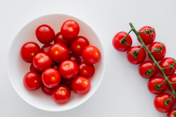Top view of ripe cherry tomatoes in bowl on white background  - Φωτογραφία, εικόνα