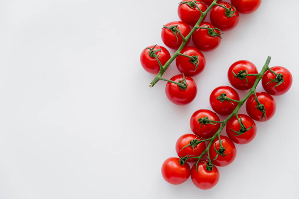 Top view of fresh ripe cherry tomatoes on branches on white background  - Photo, Image
