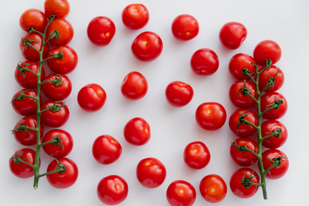 Top view of organic cherry tomatoes on branches on white background  - Foto, afbeelding