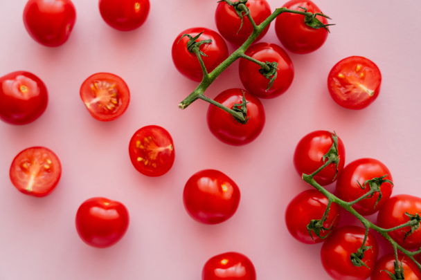Pembe arka planda dallarda olgun kiraz domateslerinin üst görüntüsü  - Fotoğraf, Görsel