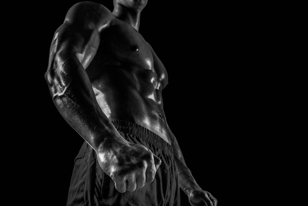 Part of a mans body on a dark background with copyspace. Studio shot on black background. - Foto, afbeelding