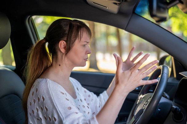 Egy nő neheztel a vezetésre egy autóbaleset után. nő vezetés egy autó. - Fotó, kép