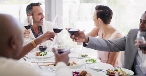 Farklı ırklardan çok sayıda arkadaşın bir restoranda öğle yemeği yiyip bir kadeh kırmızı şarabın tadını çıkarırken tezahürat yaptığı yakın çekim. Bir grup arkadaş salata yiyor ve kutlama yapıyorlar. - Video, Çekim