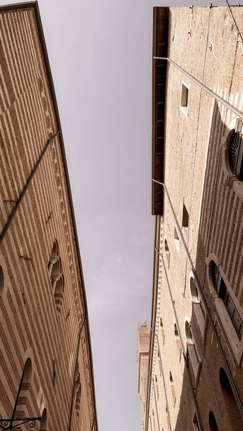 Verona, Olaszország-Március 19, 2022: Gyönyörű régi épületek Verona. a középkor tipikus építészete. Légi kilátás a városra, kék ég a háttérben, gyönyörű kilátás az adige folyóra. - Fotó, kép