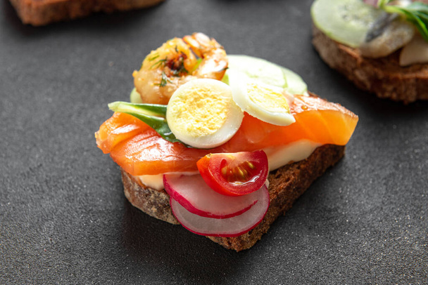 Smorrebrod, tradicional danés abierto sanwiches vista superior en la placa oscura - Foto, imagen