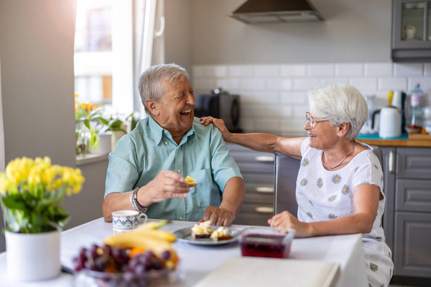 Senior couple having breakfastand talking - Foto, afbeelding