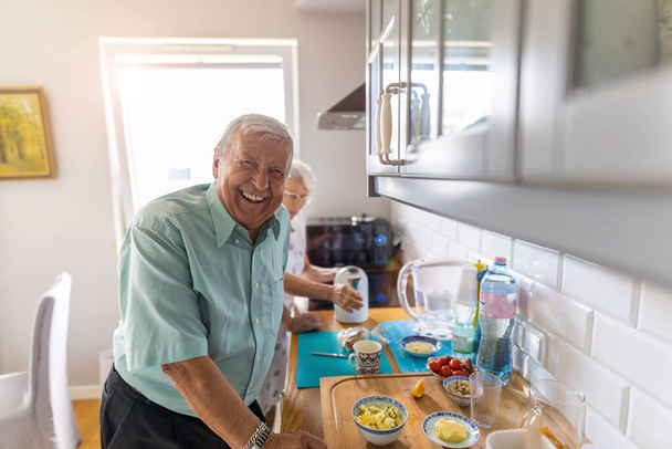 Senior couple in a kitchen making breakfast  - Valokuva, kuva