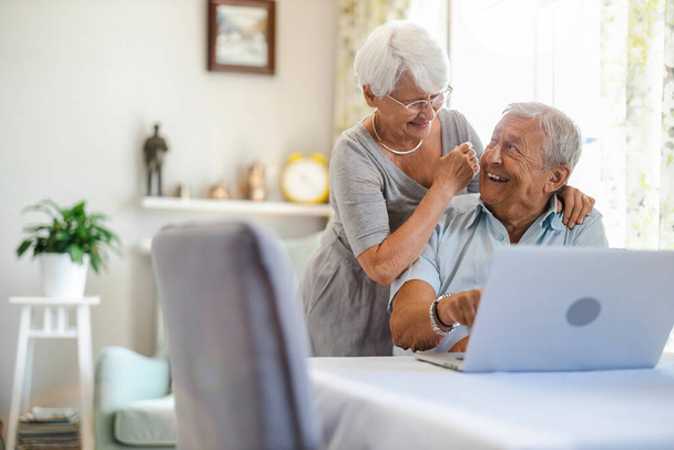 glückliches Seniorenpaar mit Laptop zu Hause - Foto, Bild