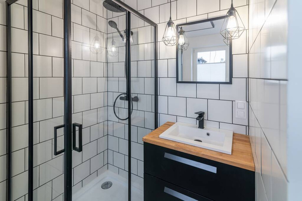 Banheiro moderno com lavatório e cabine de duche. Azulejos brancos nas paredes e articulações pretas - Foto, Imagem