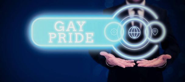 Textschild mit Gay Pride, Wort über die Würde eines Idioten, das entweder einem Mann oder einem Geschäftsmann im Anzug gehört und eine geöffnete Handfläche als Symbol für erfolgreiche Teamarbeit trägt. - Foto, Bild