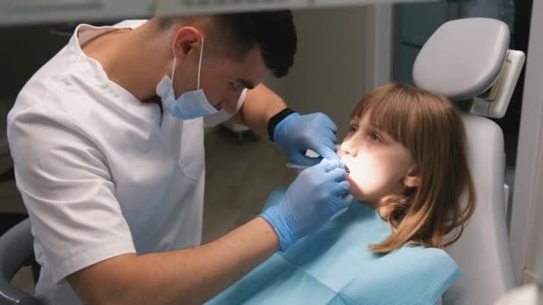 Schattig klein meisje bij de tandarts. Klein meisje zit in het tandartspraktijk. - Video