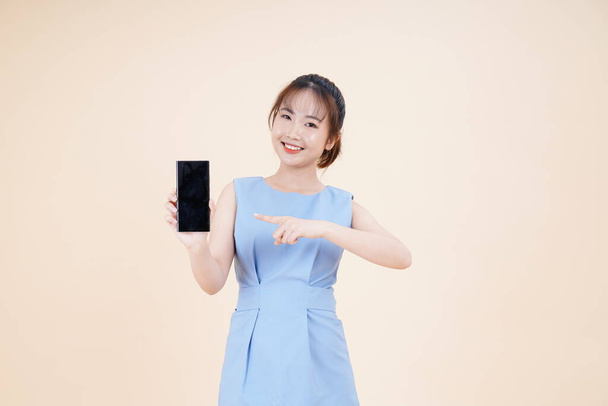 Portrait of Asian young beautiful and cheerful woman, using smart phone, isolated on background - Foto, Imagen
