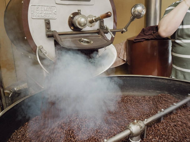 コスタリカのバイオエシカル農業の生の緑のコーヒー豆はデンティ・トーレフィアツィオーネでイタリアのクレモナで焙煎 - 写真・画像