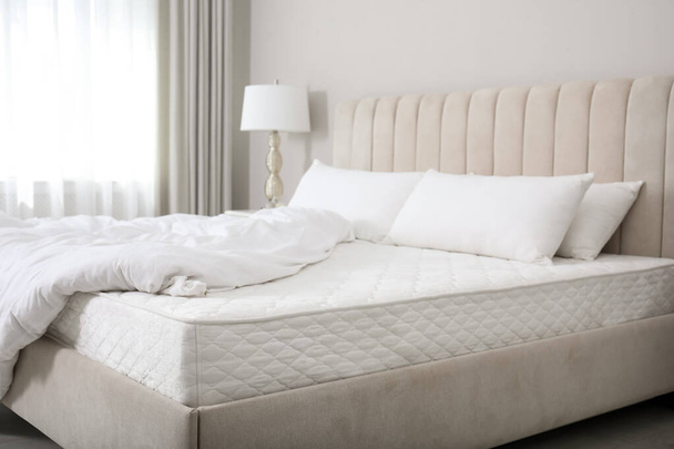 Comfortable bed with soft white mattress, blanket and pillows indoors - Fotó, kép