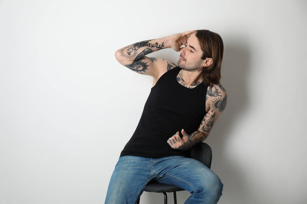 Young man with tattoos on body against white background - Fotoğraf, Görsel