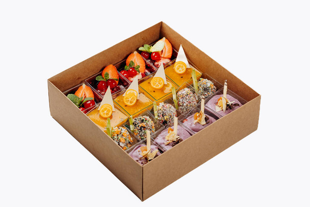 Las porciones diferentes de los postres con la jalea y la fruta en la caja son listas para la entrega - Foto, imagen