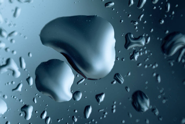 Капли воды на стекле для фона, макрофотографии, синего оттенка - Фото, изображение