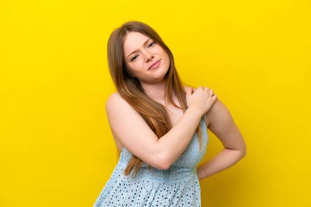 Young caucasian woman isolated on yellow background suffering from pain in shoulder for having made an effort - Fotografie, Obrázek