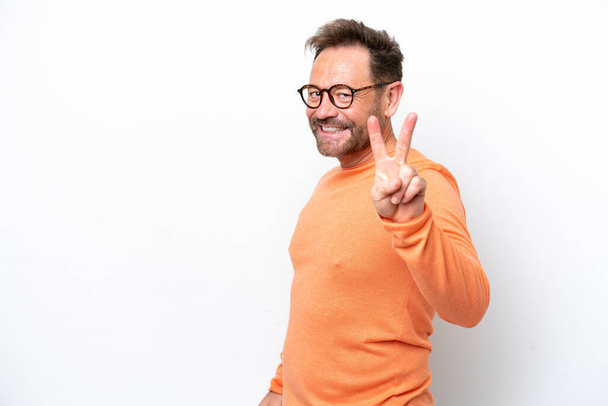 Middle age caucasian man isolated on white background smiling and showing victory sign - Fotó, kép