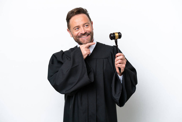 Középkorú bíró férfi elszigetelt fehér háttér néz oldalra, és mosolyog - Fotó, kép