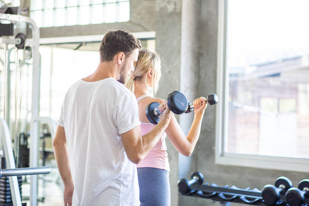 Sportief paar maken gewicht tillen samen in loft sportschool gezonde levensstijl - Foto, afbeelding