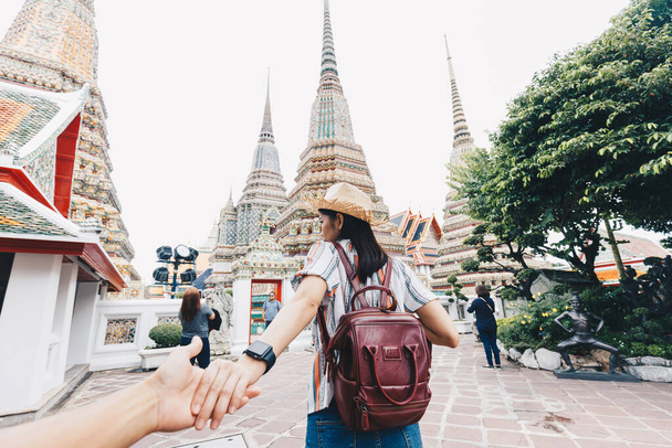 Asian women leading man hand follow travel in buddhist temple couple relationship Bangkok Thailand - Foto, Imagen
