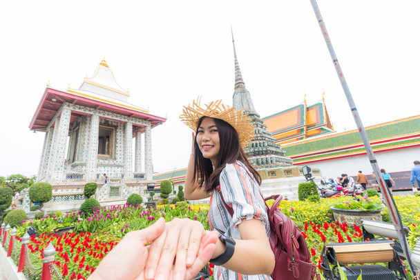 Turistické ženy vedoucí muž ruční cestování v chrámu sochy Buddhy Bangkok Thajsko - Fotografie, Obrázek