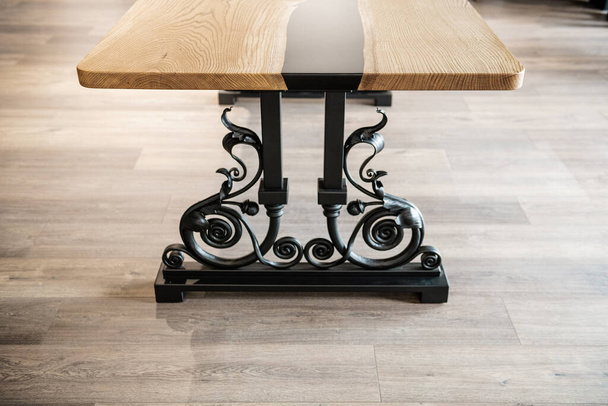 table made of wood and black epoxy resin on wrought metal legs - Fotó, kép