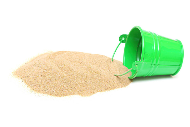 Pile of dry sand and miniature green bucket isolated on white background. - Photo, Image