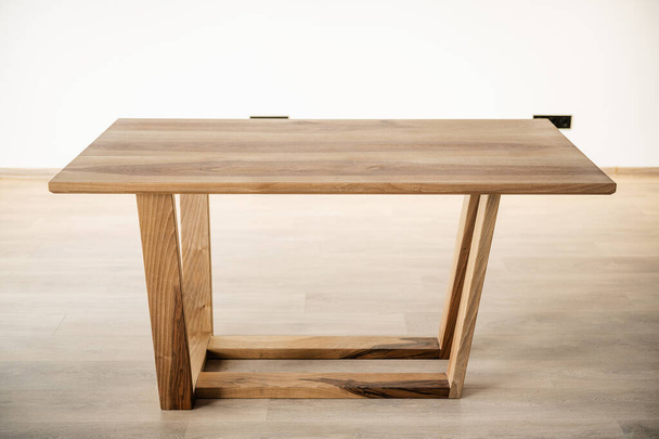 φυσικό ξύλινο τραπέζι σε ξύλινα πόδια στο εσωτερικό - Φωτογραφία, εικόνα