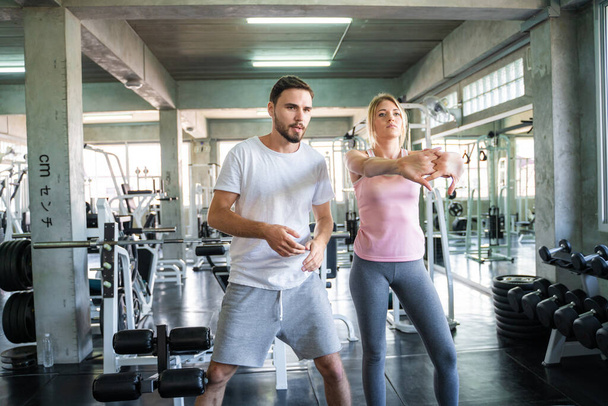 Couple stretch body before exercise in sport gym together private trainer healthy lifestyle - Fotoğraf, Görsel