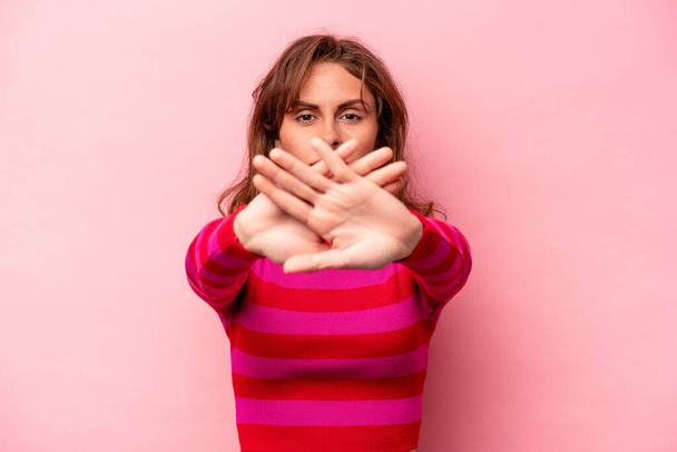 Young caucasian woman isolated on pink background doing a denial gesture - Fotó, kép