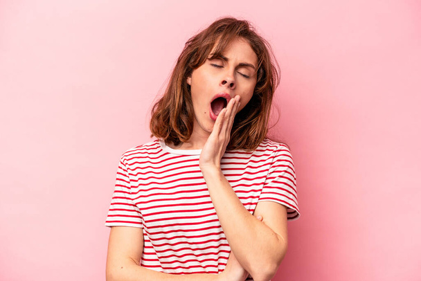 Mladá běloška žena izolované na růžovém pozadí zívání ukazující unavené gesto zakrývající ústa s rukou. - Fotografie, Obrázek