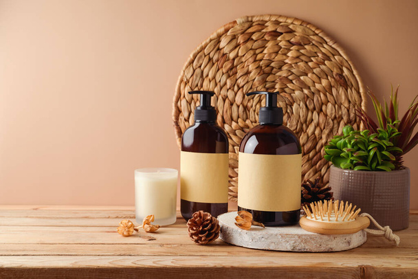 Natural beauty products concept. SPA cosmetics bottles with labels for mock up packaging design on wooden table over beige background.  - Photo, Image