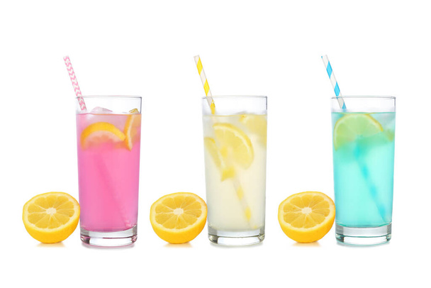 Cold, colorful summer lemonade drinks. Pink, yellow and blue colors in tall glasses with lemons isolated on a white background. - Photo, Image