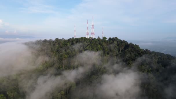 霧の低い雲の上の丘の頂上にある4つの通信塔への空中移動 - 映像、動画