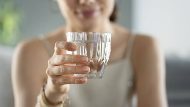 若い女性がコップ一杯の水を飲み - 写真・画像