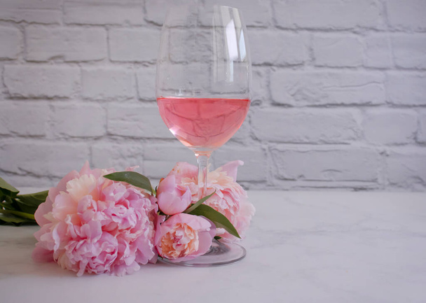 Rose wine, peony flower on a light background - Photo, Image