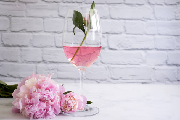 Rose wine, peony flower on a light background - Photo, Image