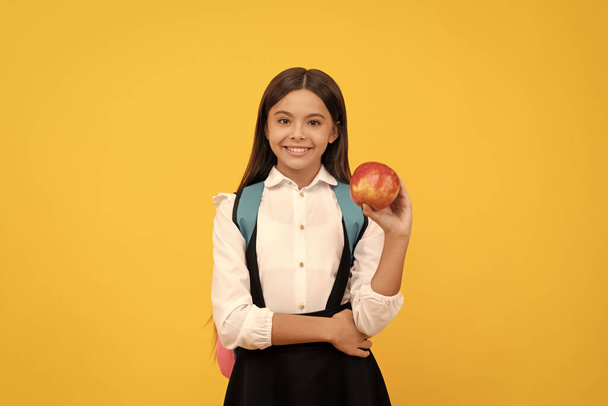 Ήρθε η μέρα της γνώσης. Ευτυχισμένο κορίτσι χαμογελάει κρατώντας μήλο. Ημέρα γνώσης. Εκπαίδευση τροφίμων. Επιστροφή στο σχολείο. 1η Σεπτεμβρίου. - Φωτογραφία, εικόνα