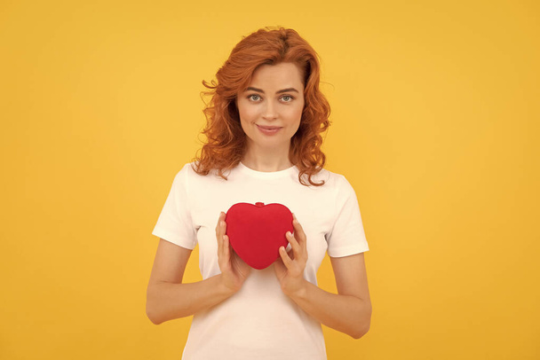 portrait of girl with heart. happy valentines day. be my valentine. lady on yellow background. love present. smiling redhead woman with love romantic gift. sweetheart. valentines sale. - Photo, Image