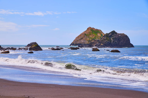 Εικόνα των μεγάλων βράχων στον ωκεανό με αμμώδη παραλία και κύματα συντρίβεται - Φωτογραφία, εικόνα
