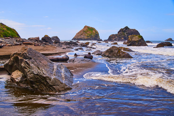 砂浜と海の波がクラッシュするロッキー海岸の画像 - 写真・画像