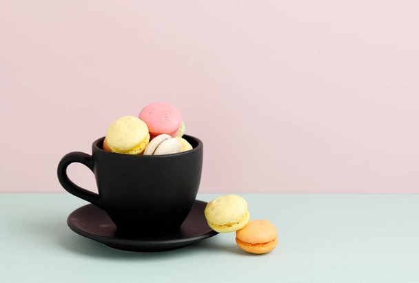 Mini Macaroon on Black Cup, Copy Space on Pastel Background. Copy Space for Text or Advertisement - Photo, Image