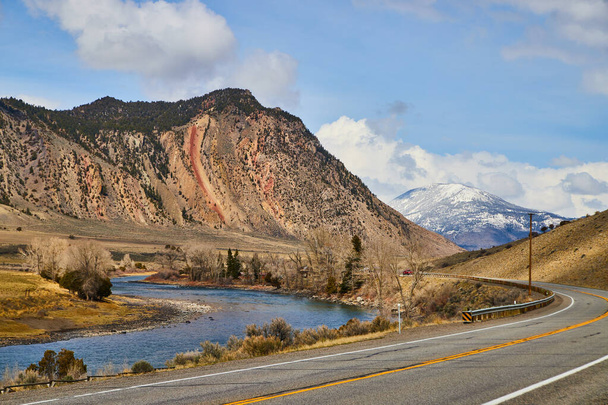 Image of Road winding through snowy mountains by river - Photo, Image