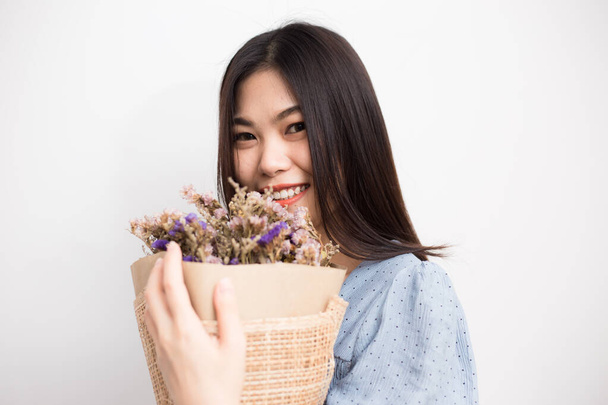 Güzel, mutlu, gülümseyen bir kadın beyaz arka planda kurumuş çiçek buketi tutuyor. - Fotoğraf, Görsel